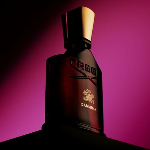 Creed Carmina perfume bottle with purple background.