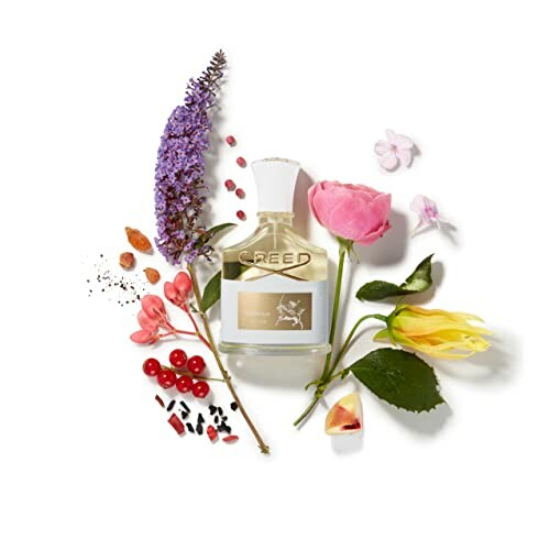 Creed perfume bottle surrounded by flowers and spices.