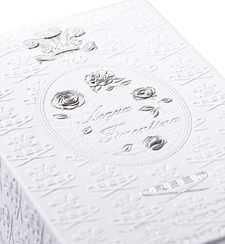 Elegant white embossed packaging with floral design.