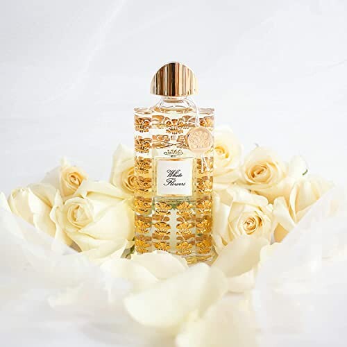 Elegant perfume bottle surrounded by white roses