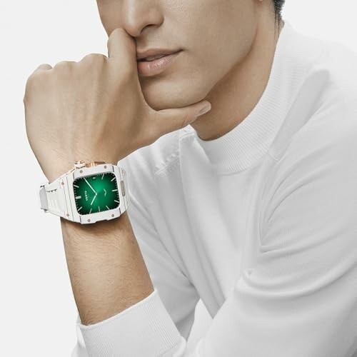 Man wearing a stylish watch with a green face and white band