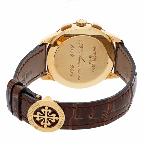 Gold Patek Philippe watch with engraved back and brown leather strap.